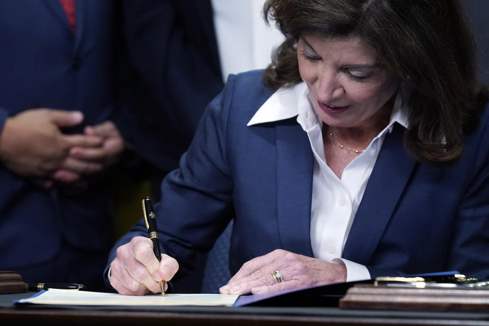 New York Gov. Kathy Hochul signs the "Less is More" law, during ceremonies in the governor's office, in New York, Friday, Sept. 17, 2021. New Yorkers will be able to avoid jail time for most nonviolent parole violations under a new law that will take effect in March, and largely eliminates New York's practice of incarcerating people for technical parole violations. (AP Photo/Richard Drew)