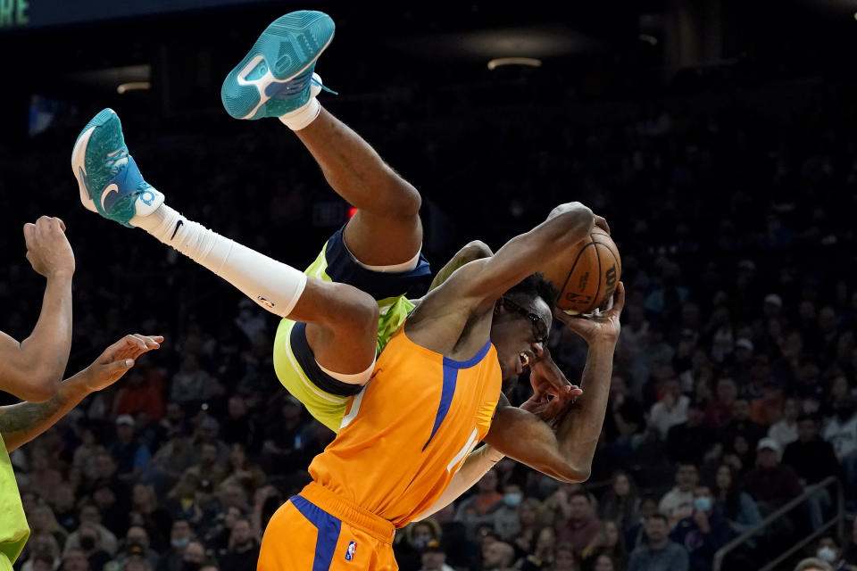 Minnesota Timberwolves forward Jaden McDaniels fouls Phoenix Suns forward Jalen Smith, right, during the second half of an NBA basketball game, Friday, Jan. 28, 2022, in Phoenix. The Suns defeated the Timberwolves 134-124. (AP Photo/Matt York)