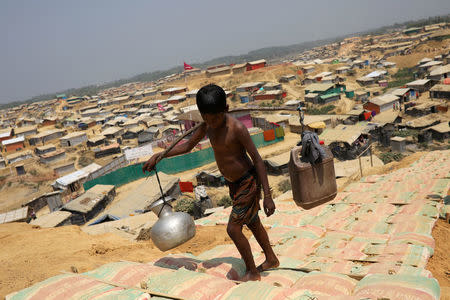 A Rohingya refugee boy carries water in the Kutupalong refugee camp, in Cox's Bazar, Bangladesh March 22, 2018. REUTERS/Mohammad Ponir Hossain