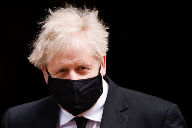 Britain's PM Johnson walks outside Downing Street, in London