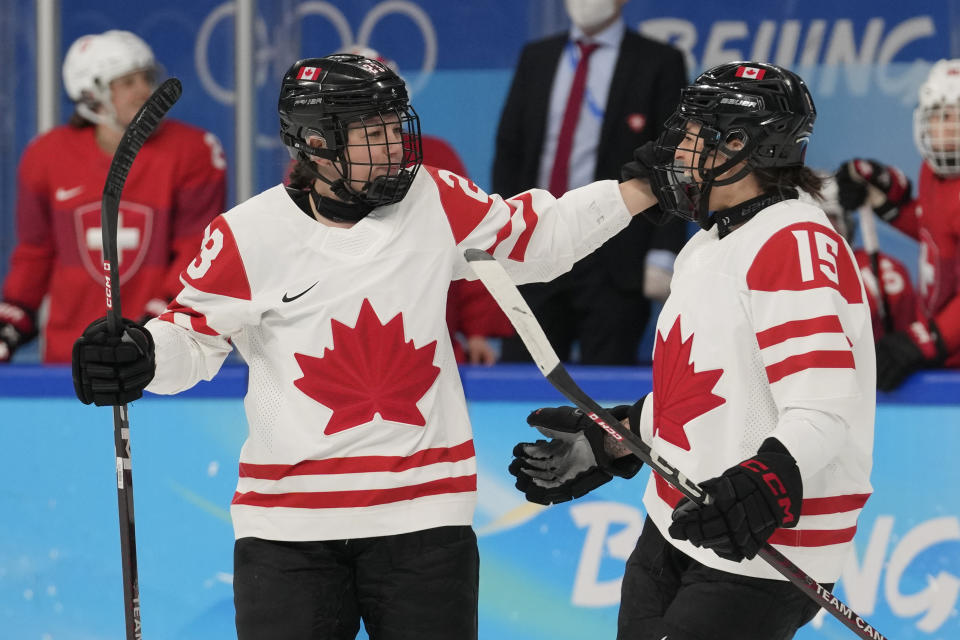Canada's Erin Ambrose (23) and Melodie Daoust (15) celebrate after Ambrose scored a goal against Switzerland during a women's semifinal hockey game at the 2022 Winter Olympics, Monday, Feb. 14, 2022, in Beijing. (AP Photo/Petr David Josek)