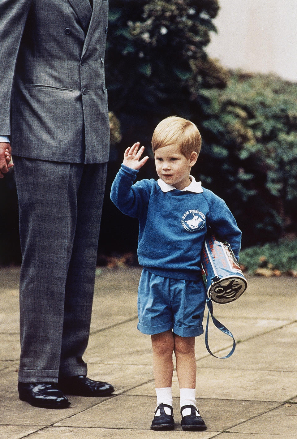 FILE - In this Sept. 16, 1987 file photo, Britain's Prince Harry waves to photographers on his first day at a kindergarten in Notting Hill, West London. Princess Diana’s little boy, the devil-may-care red-haired prince with the charming smile is about to become a father. The arrival of the first child for Prince Harry and his wife Meghan will complete the transformation of Harry from troubled teen to family man, from source of concern to source of national pride. (AP Photo/Martin Cleaver, File)