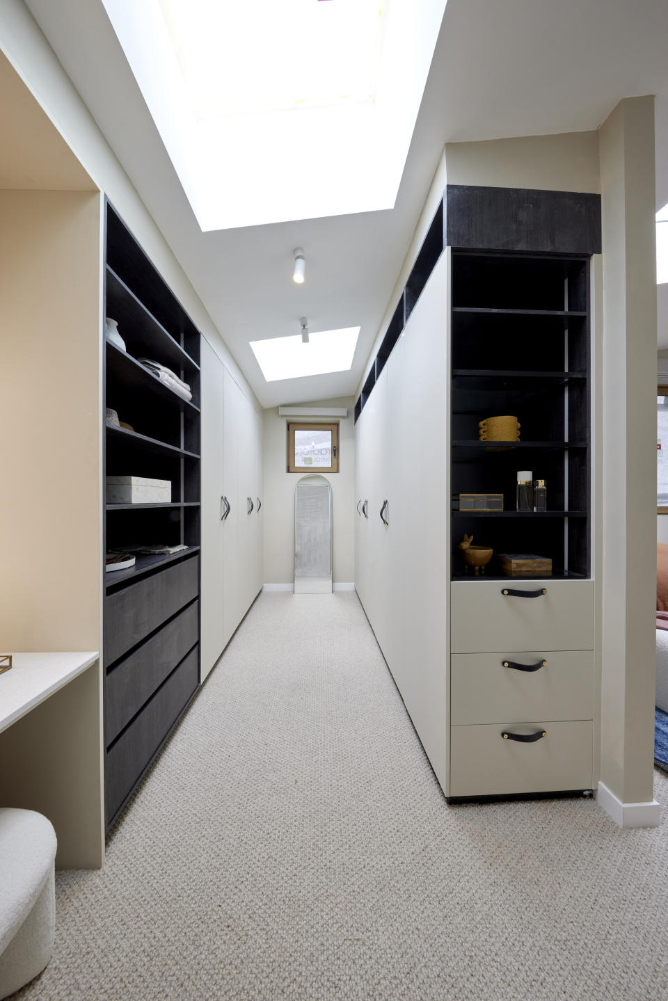 A shot down the centre of the walk-in robe with shelving and cupboard doors on either side. 