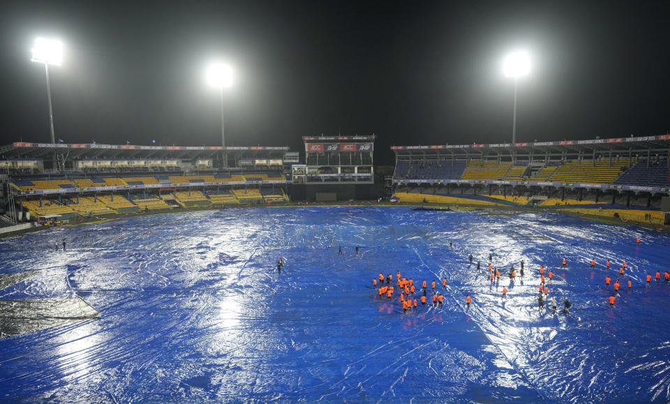 Ground staff stand on the covered field after the rain interrupted the Asia Cup cricket match between India and Pakistan in Colombo, Sri Lanka, Sunday, Sept.10, 2023. (AP Photo/Eranga Jayawardena)