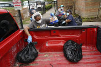 Houston Independent School District Nutrition Services workers load food into a pickup truck Monday, April 6, 2020, in Houston. HISD relaunched their food distribution efforts throughout the district Monday, with a streamlined process that will implement increased safety measures. (AP Photo/David J. Phillip)