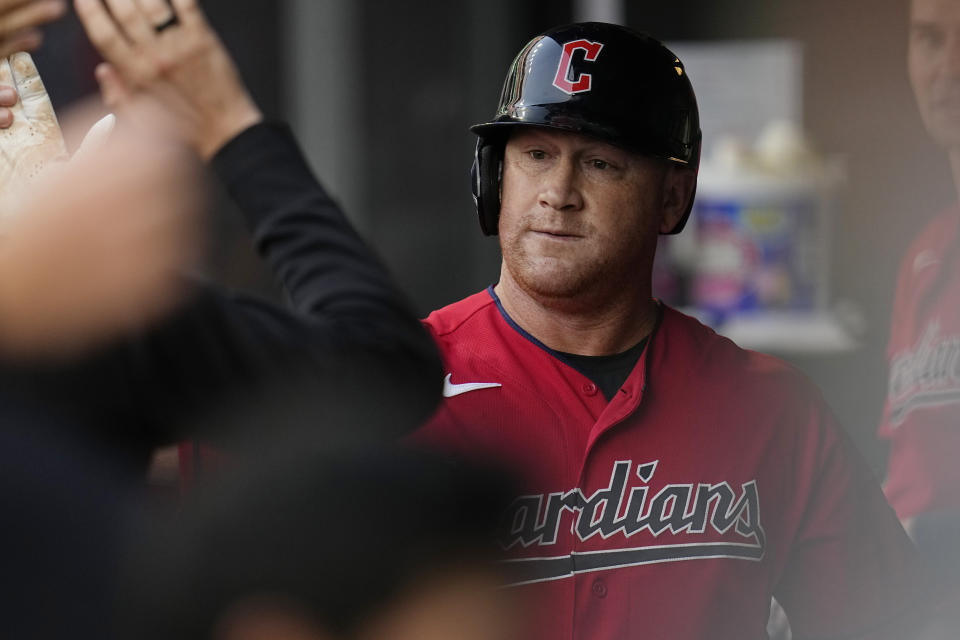 Cleveland Guardians' Kole Calhoun celebrates in the dugout after hitting a home run in the first inning of a baseball game against the Detroit Tigers, Saturday, Aug. 19, 2023, in Cleveland. (AP Photo/Sue Ogrocki)