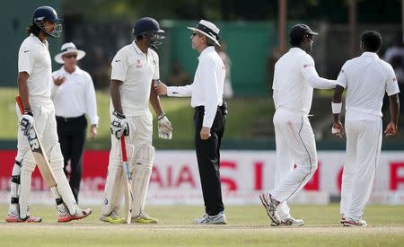 Umpire Nigel Llong (C) speaks with India's Ishant Sharma (L) and Ravichandran Ashwin (2nd L) as Sri Lanka's captain Angelo Mathews (2nd R) leads Dhammika Prasad away from an argument with Sharma during the fourth day of their third and final test cricket match in Colombo August 31, 2015. REUTERS/Dinuka Liyanawatte