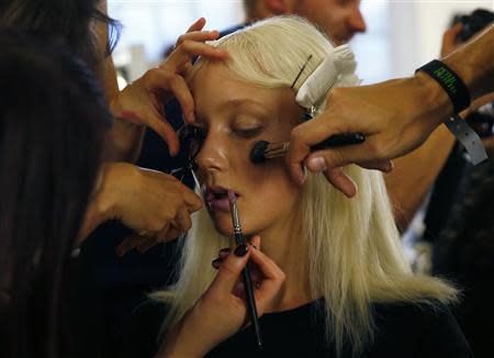 Stylists work on a model backstage before the Peter Pilotto Spring/Summer 2014 collection during London Fashion Week September 16, 2013. REUTERS/Eddie Keogh
