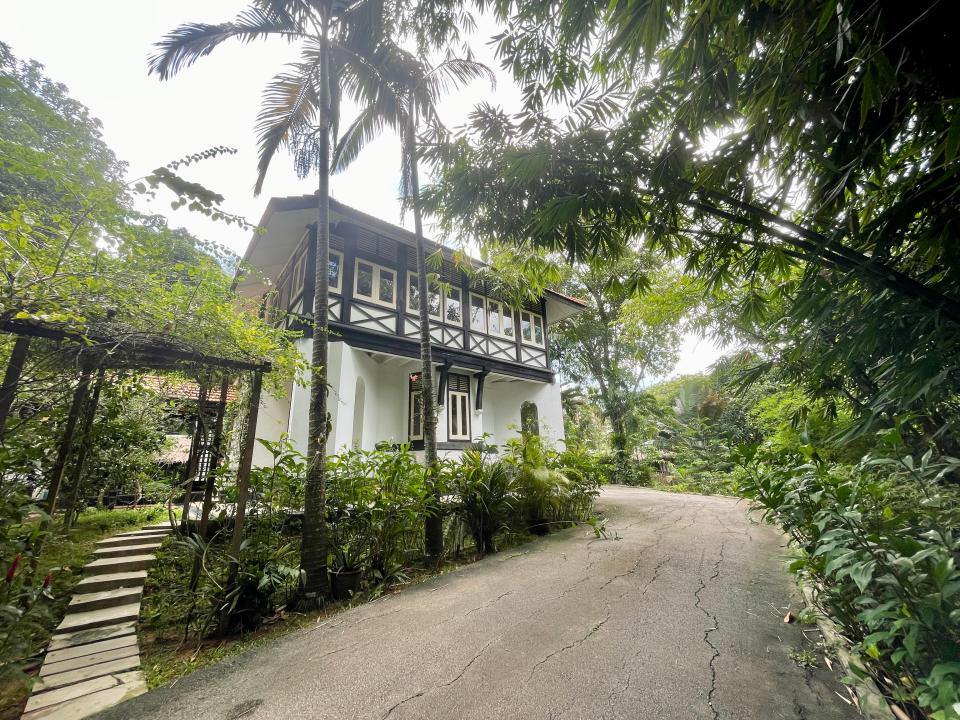 There is a driveway leading up to the main house from the gate.