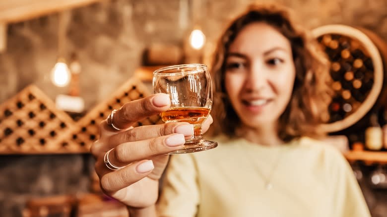 woman holding glass of whiskey
