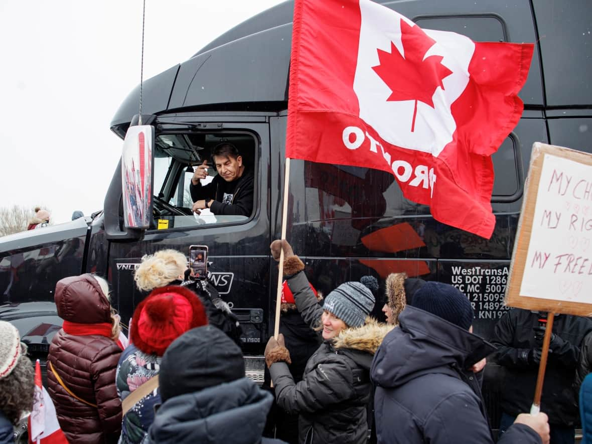 Supporters of the truck convoy cheer drivers as they make their way through Vaughan, Ont., on Thursday. (Evan Mitsui/CBC - image credit)