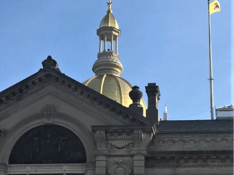 The golden dome of New Jersey's Statehouse rises into the sky above Trenton.