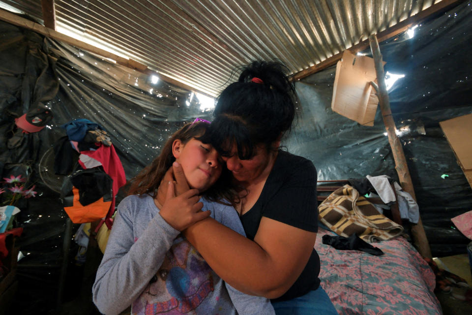  Silvina Rizo, de 39 años, que acude a comedores populares cuando no tiene suficiente dinero para comprar comida para sus hijos, abraza a su hija, Eva Violeta Núñez Rizo, de 9 años, en su casa en un asentamiento de Salta, Argentina, el 12 de septiembre de 2024. REUTERS/Javier Corbalan/Foto de archivo