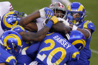 San Francisco 49ers running back Raheem Mostert, center, is tackled by Los Angeles Rams defenders during the first half of an NFL football game in Santa Clara, Calif., Sunday, Oct. 18, 2020. (AP Photo/Tony Avelar)