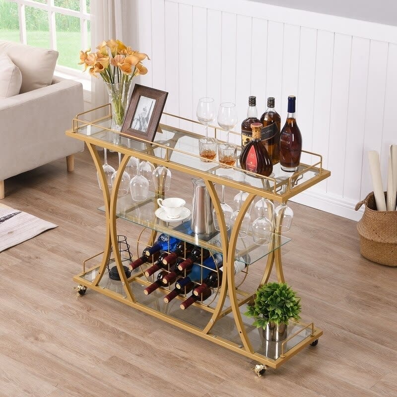 gold-tone bar cart with liquor bottles, glasses, and wine bottle storage