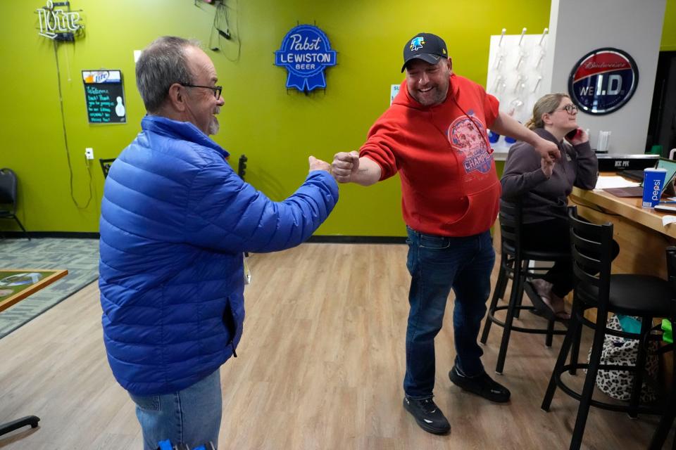 Justin Juray, right, owner of Just In Time Recreation, bumps fists with local bowler Moe St. Pierre, Wednesday, May 1, 2024, in Lewiston, Maine. The bowling alley, where eight people were killed in last October's mass shooting, was scheduled to reopen Friday, May 3. (AP Photo/Robert F. Bukaty)