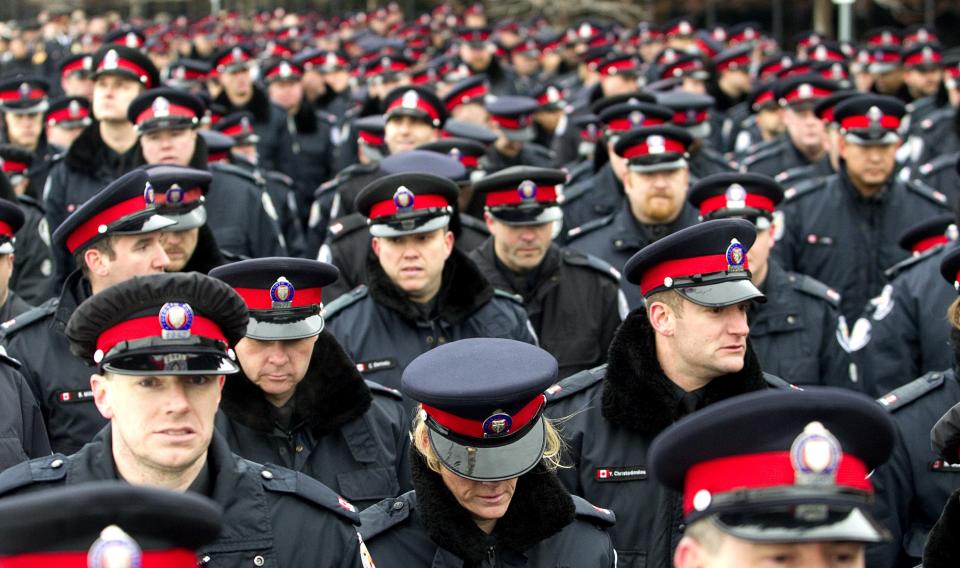Officers file into a public memorial for police constable John Zivcic in Toronto
