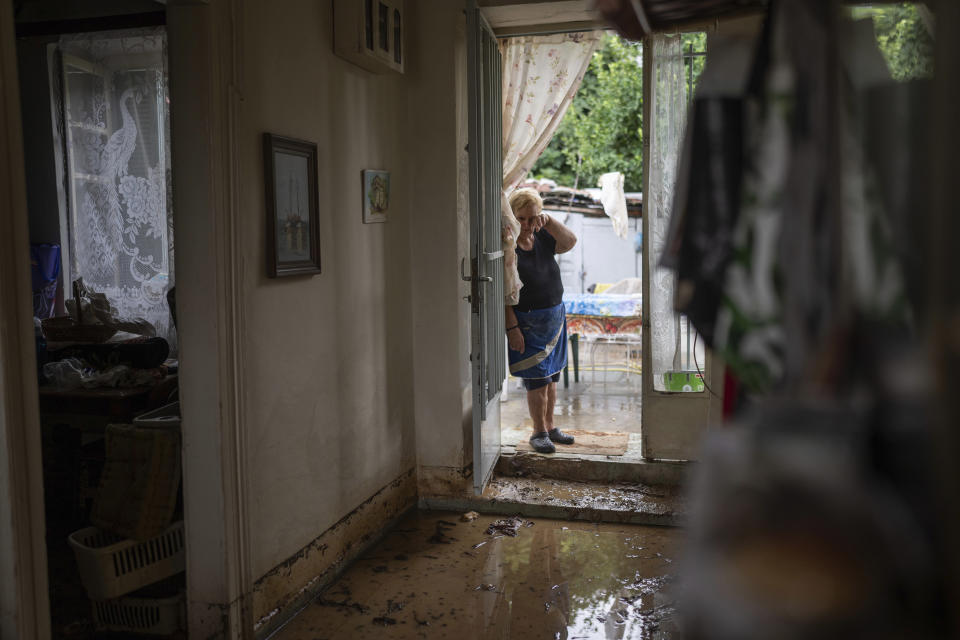 Georgia Sirtarioti, 76, stands at the doorstep of her flooded home in the storm-hit city of Volos, Greece, where power and water outages remained in some districts, Friday, Sept. 29, 2023. Bad weather has eased in central Greece leaving widespread flooding and infrastructure damage across the farming region that has been battered by two powerful storms in less than a month. (AP Photo/Petros Giannakouris)