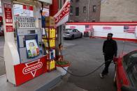 FILE PHOTO: A person pumps gasoline at a Conoco gas station, a brand owned by Phillips 66, in Brooklyn, New York