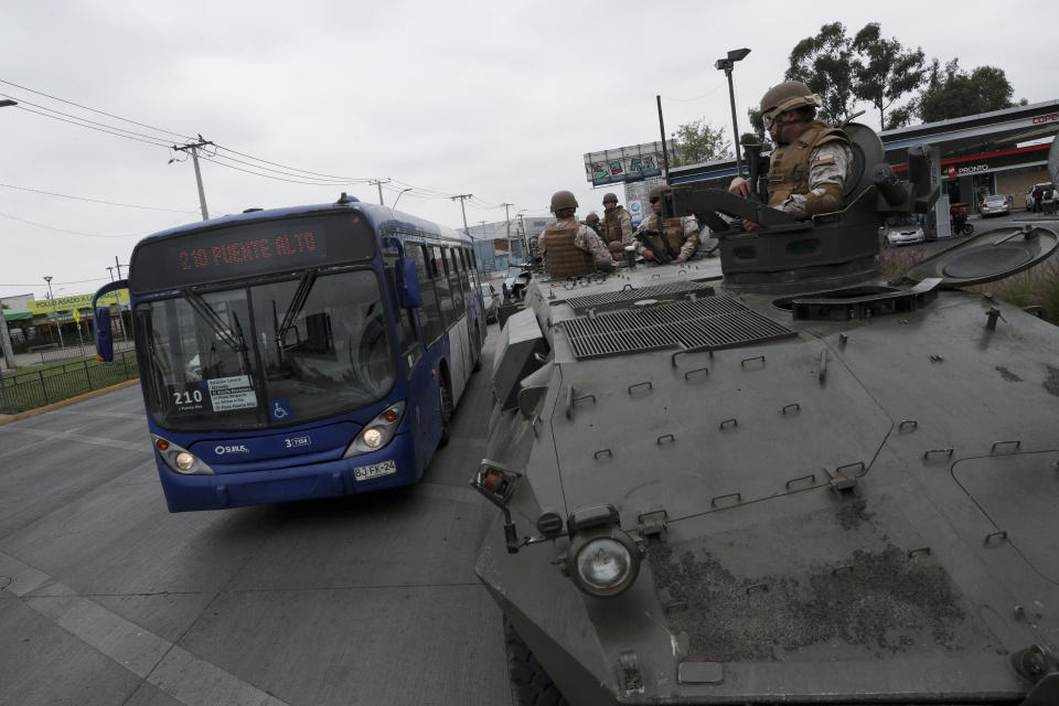 Soldiers of armored vehicles guard a junction in Santiago, Chile, Sunday, Oct. 20, 2019. Chilean President Sebastián Piñera on Saturday announced the suspension of a subway fare hike that had prompted violent student protests, less than a day after he declared a state of emergency amid rioting and commuter chaos in the capital. (AP Photo/Esteban Felix)