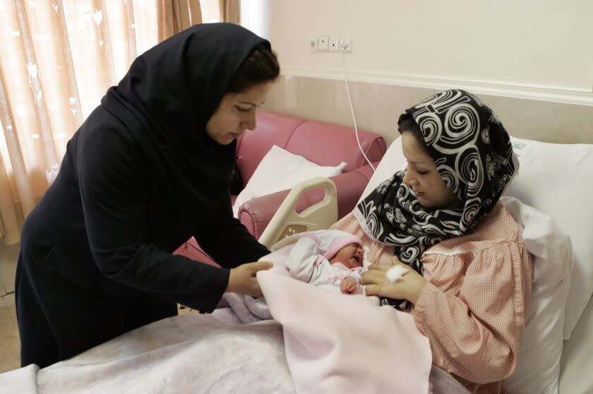 Iranian nurse Zahra Akbarzadeh, left, gives one-day-old baby girl Setayesh to her mother, Tayyebeh Sadat Bidaki, to feed her at the Mehr hospital, in Tehran, Sunday, July 29, 2012. In a major reversal of once far-reaching family planning policies, Iran is now slashing its birth-control programs in an attempt to avoid an aging demographic similar to many Western countries that are struggling to keep up with state medical and social security costs. (AP Photo/Vahid Salemi)