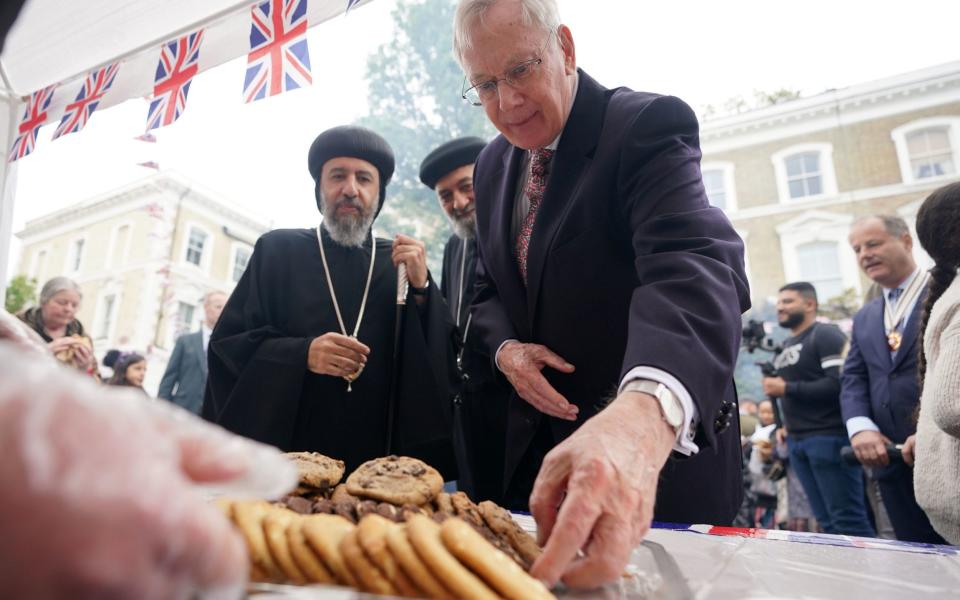 The Duke of Gloucester helps himself to a biscuit - PA