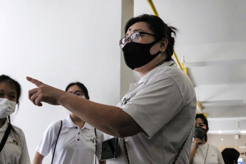 Keeping Hope Alive founder Fion Phua briefs members before their volunteer work Sunday, Oct. 4, 2020 in Singapore. Members of the volunteer group conduct weekend door-to-doorvisits to deliver goods or provide services to people in need. (AP Photo/Ee Ming Toh)