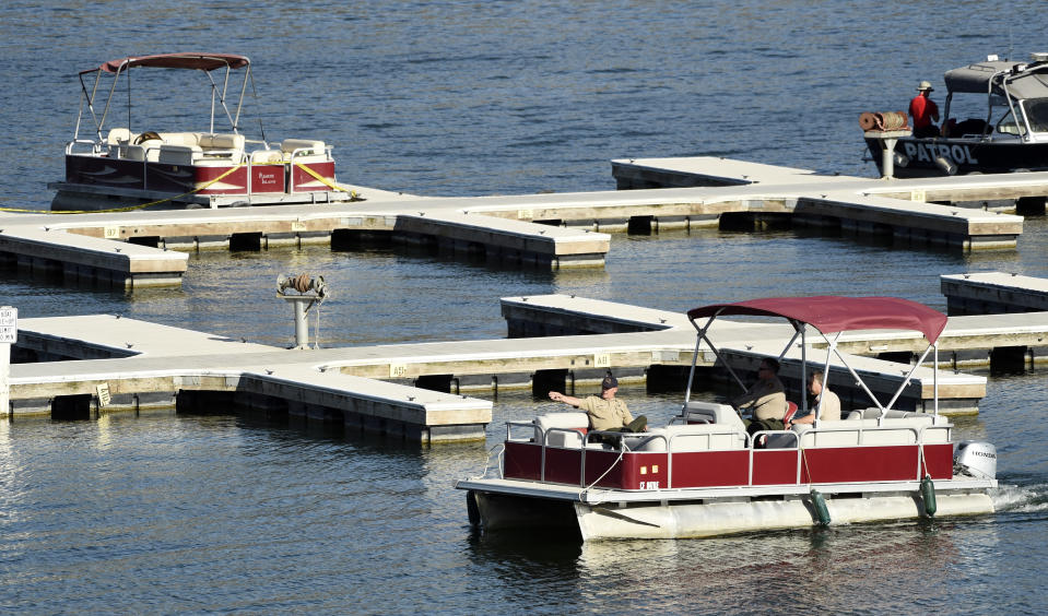 A search and rescue team moves past a rental boat at top left that was used by actress Naya Rivera and her 4-year-old son on Lake Piru on Thursday, July 9, 2020, in Los Padres National Forest, northwest of Los Angeles. Authorities said Thursday that they believe “Glee” star Rivera drowned in the lake but they are continuing the search for her a day after her 4-year-old son was found alone in a rented boat. “Investigators believe Rivera drowned in what appears to be a tragic accident,” a Ventura County Sheriff's Office statement said. (AP Photo/Chris Pizzello)