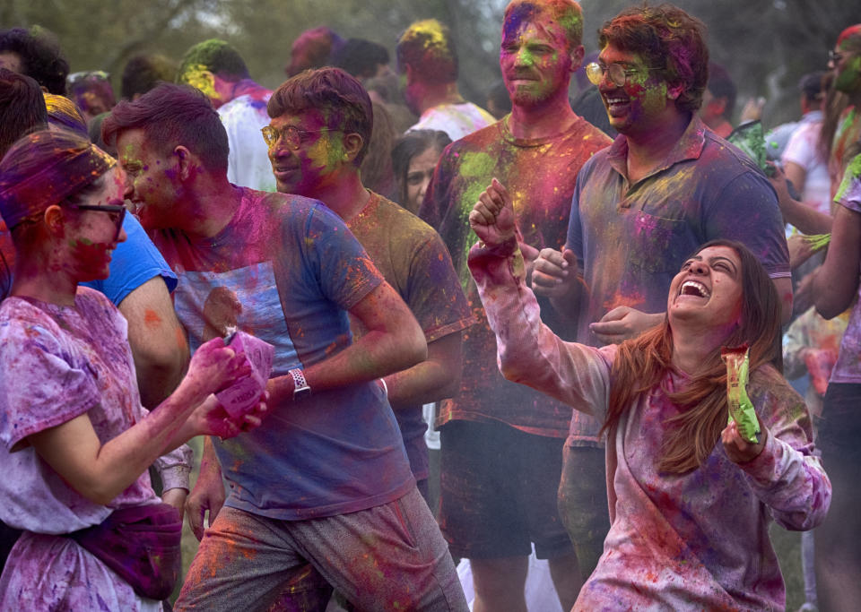 Devotees dance and throw colored powder as they celebrate Holi, the Hindu festival of colors, in the Encino section of Los Angeles on Sunday, March 24, 2024. (AP Photo/Richard Vogel)