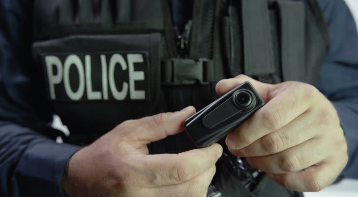 An image of a police officer holding a body camera