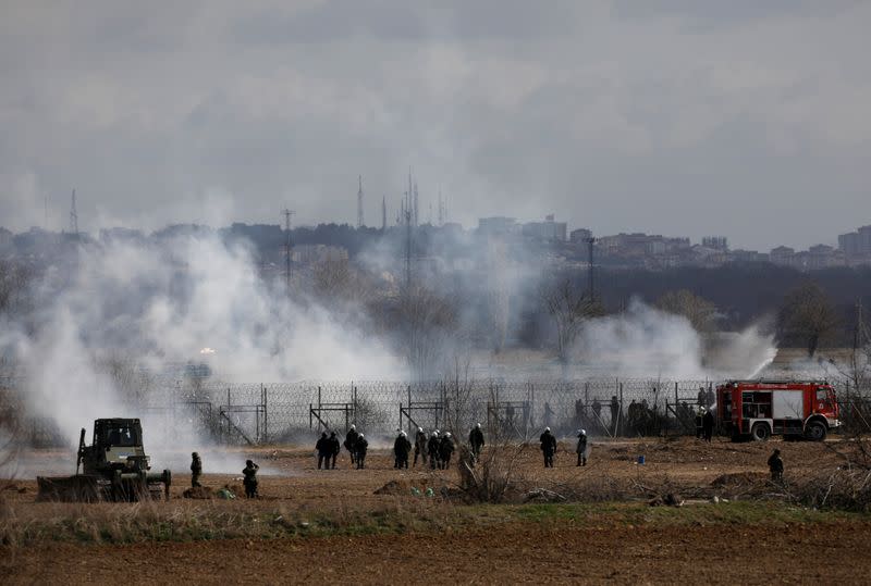 Greek soldiers and riot police officers stand amid clouds of tear gas near Turkey's Pazarkule border crossing, in Kastanies