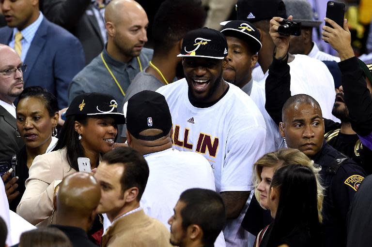 LeBron James (C) of the Cleveland Cavaliers celebrates with wife Savannah Brinson (L) and teammates after defeating the Atlanta Hawks during Game Four of their NBA Eastern Conference finals, at Quicken Loans Arena in Cleveland, Ohio, on May 26, 2015