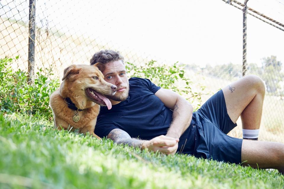 Gus Kenworthy laying in grass with Birdie