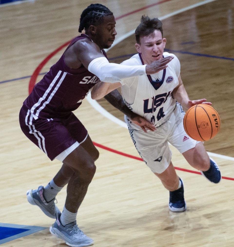 Southern Indiana’s Jack Campion (24) drives the ball past Southern Illinois’ Lance Jones (5) as the University of Southern Indiana Screaming Eagles play Southern Illinois Salukis at Screaming Eagles Arena in Evansville, Ind.,  Sunday afternoon, Nov. 13, 2022. 