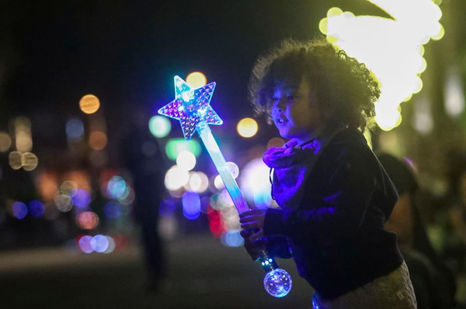 Alumiere Glass, 3, of Palm Springs holds her magic wand while watching the Festival of Lights Parade, Saturday, Dec. 4, 2021, in Palm Springs, Calif. 