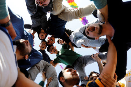 People gesture during a gathering celebrating Newroz, which marks the arrival of spring and the new year, in Diyarbakir March 21, 2018. REUTERS/Umit Bektas