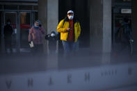 People wearing face masks to help curb the spread of the coronavirus walk into the underpass under the street during sunset in Moscow, Russia, Wednesday, Dec. 2, 2020. Russia has registered a record number of coronavirus deaths for a second straight day. Currently, there is a country-wide mask mandate and mostly mild restrictions that vary from region to region. (AP Photo/Alexander Zemlianichenko)