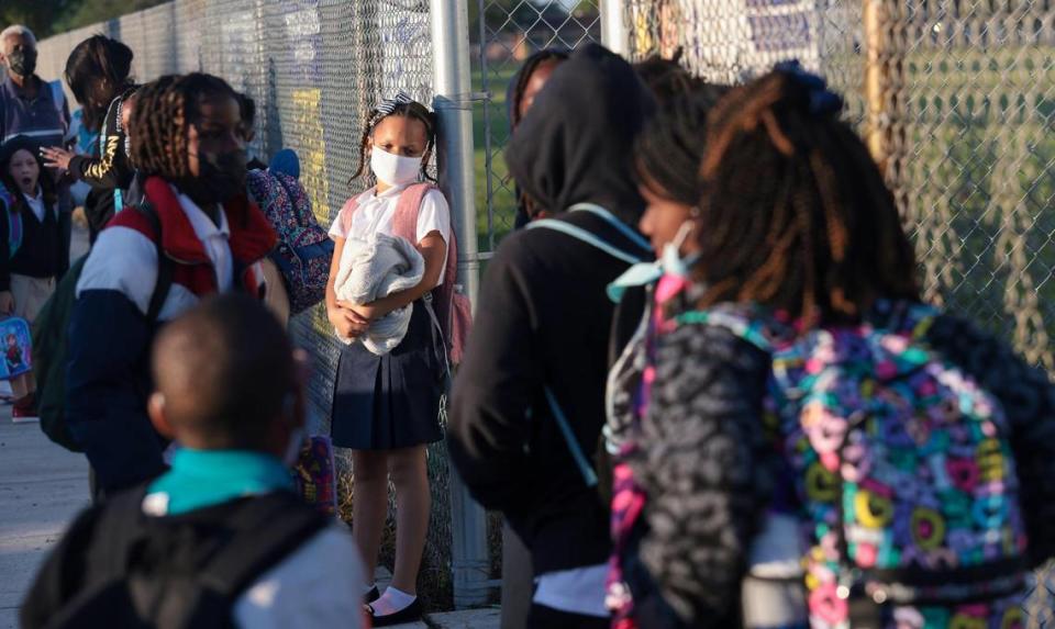 Los padres de los alumnos de preescolar a quinto grado esperan a que les dejen entrar en la escuela a primera hora de la mañana en la escuela primaria de Miami Gardens, Florida, el miércoles 17 de agosto de 2022.