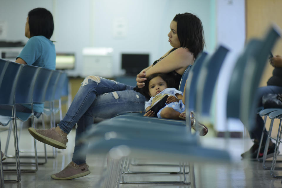 Three-year-old Ailianie Hernandez waits with her mother Julianna Ageljo to apply for the nutritional assistance program at the Department of Family Affairs, in Bayamon, Puerto Rico, Friday, March 29, 2019. Hundreds of thousands of Puerto Ricans are feeling the sting of what the territorial government says are insufficient federal funds to help the island recover from the Category 4 storm amid a 12-year recession. (AP Photo/Carlos Giusti)