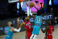 Memphis Grizzlies' Ja Morant (12) shoots over New Orleans Pelicans' Derrick Favors (22) and Zion Williamson (1) during the second half of an NBA basketball game Monday, Aug. 3, 2020 in Lake Buena Vista, Fla. (AP Photo/Ashley Landis, Pool)