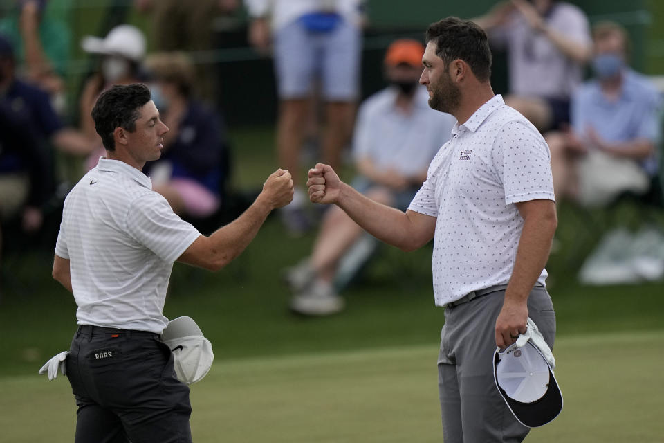 Rory McIlroy, of Northern Ireland, bumps fists with Jon Rahm, of Spain, on the 18th green during the second round of the Masters golf tournament on Friday, April 9, 2021, in Augusta, Ga. (AP Photo/Matt Slocum)