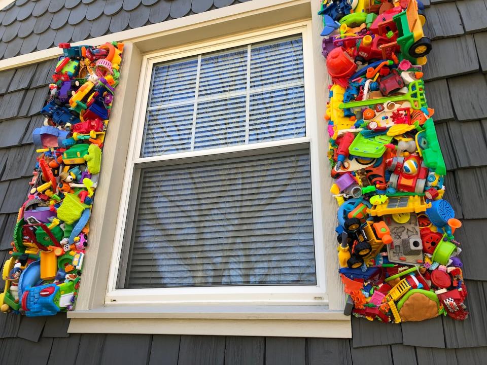 Brian MacKinnon replaced six shutters on the front of his house with children's toys that he melted together. 