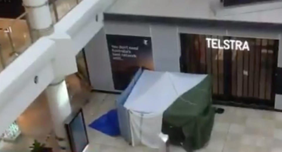 A tent houses a dead body in an established crime scene in a shopping centre in Chatswood after a man died. 