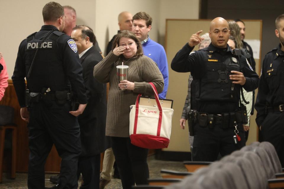 Lynn Mazurkiewicz wipes her eye after hugs from Rochester police officers.