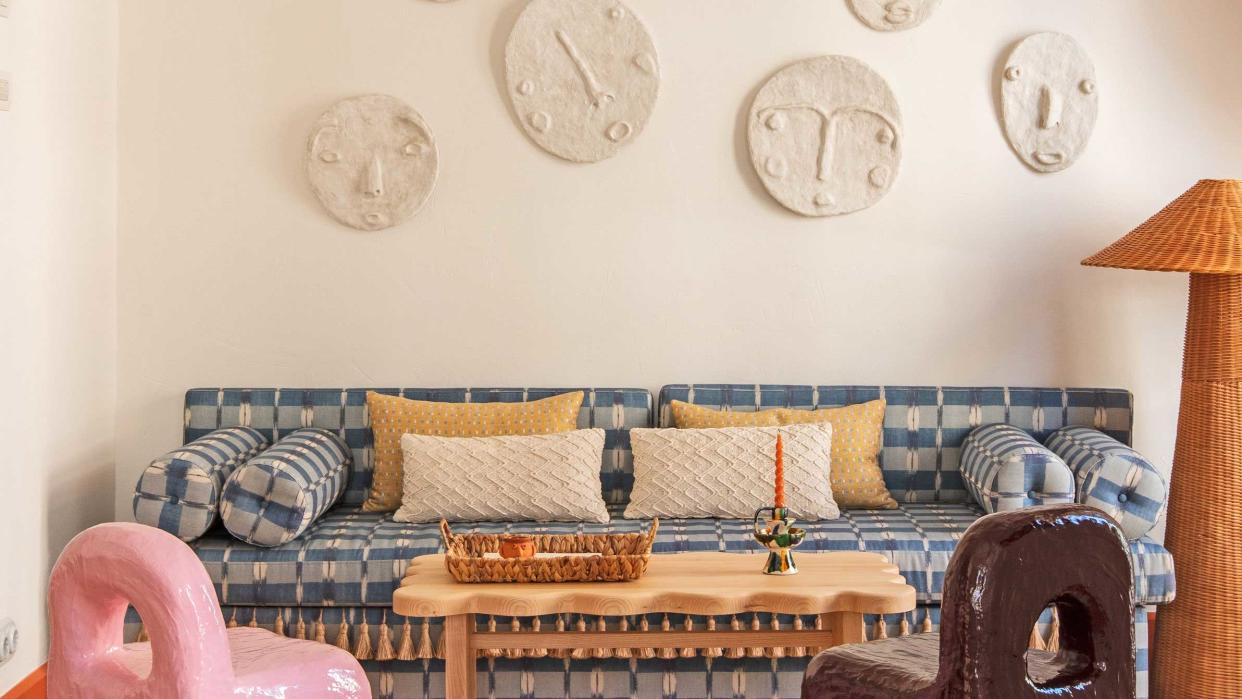  plaster relief faces above a sofa 