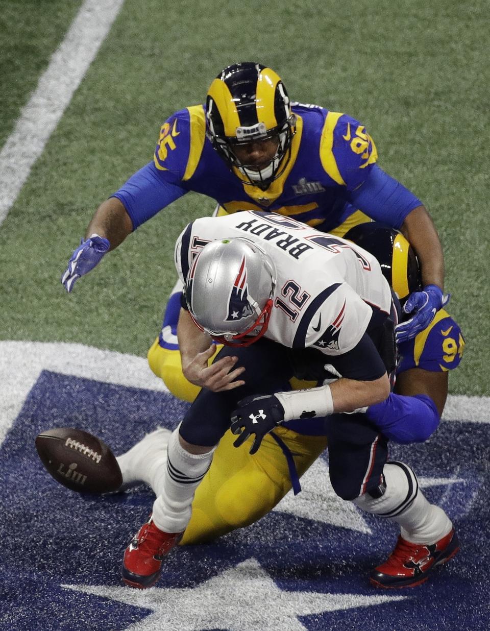 New England Patriots' Tom Brady fumbles as he is tackled by Los Angeles Rams' John Franklin-Myers (94) and Ethan Westbrooks (95) during the first half of the NFL Super Bowl 53 football game Sunday, Feb. 3, 2019, in Atlanta. (AP Photo/Charlie Riedel)