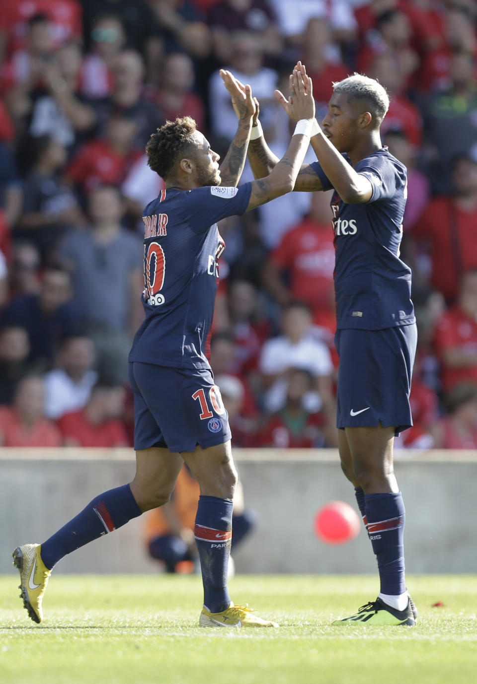 PSG's Neymar, left, celebrates with Presnel Kimpembe his opening goal during their League One soccer match between Nimes and Paris Saint-Germain at Jean-Bouin stadium in Nimes, southern France, Saturday Sept. 1, 2018. (AP Photo/Claude Paris)