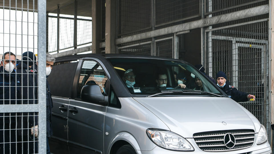 Prison police officers stand guard as the coroner's car leaves the Sant'Anna prison in Modena, Emilia-Romagna, in one of Italy's quarantine red zones on March 9, 2020. - Inmates in four Italian prisons have revolted over new rules introduced to contain the coronavirus outbreak, leaving one prisoner dead and others injured, a prison rights group said on March 8. Prisoners at jails in Naples Poggioreale in the south, Modena in the north, Frosinone in central Italy and at Alexandria in the northwest had all revolted over measures including a ban on family visits, unions said. (Photo by Piero CRUCIATTI / AFP) (Photo by PIERO CRUCIATTI/AFP via Getty Images)