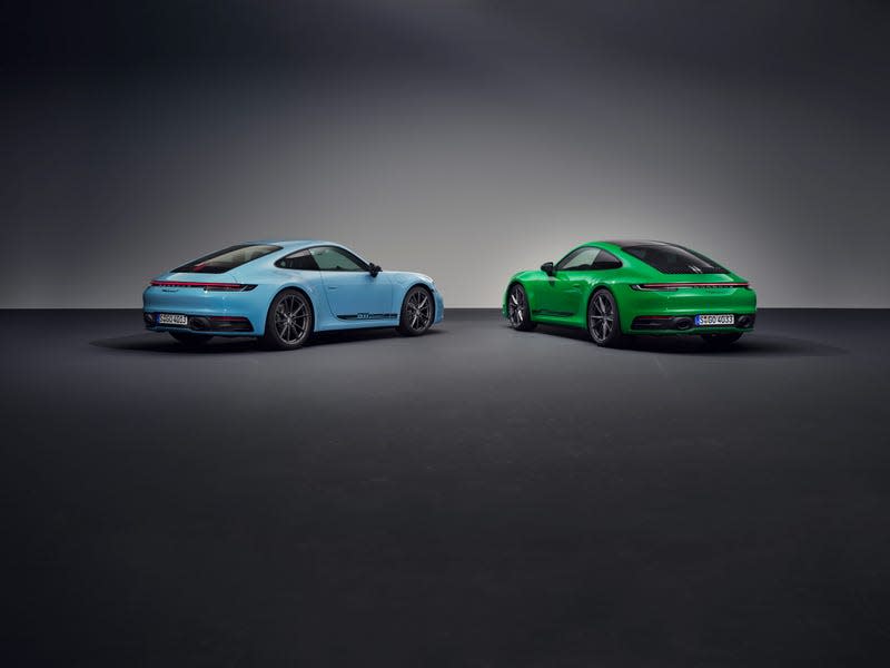 A blue 911 and a green 911 are parked, rear ends facing the camera, in front of a gray background.