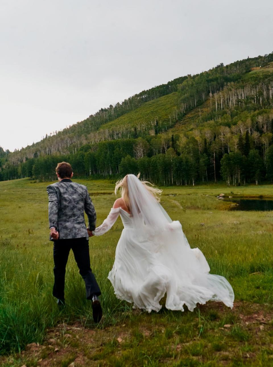 a man and woman walking in a field with a horse